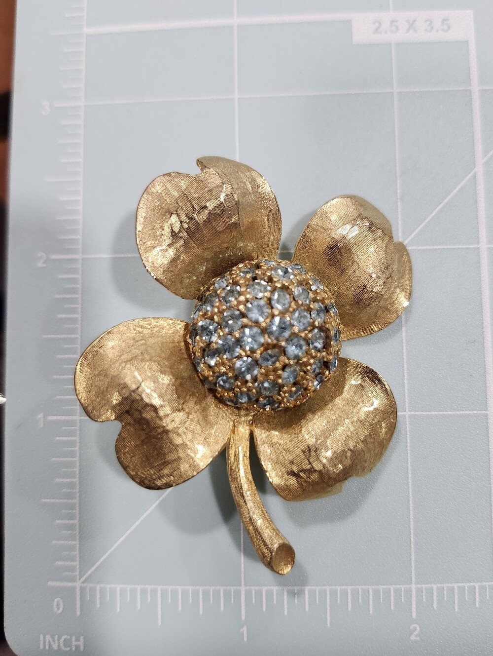 Hobé gold-tone textured Dogwood flower Brooch With Blue Rhinestone Domed Center